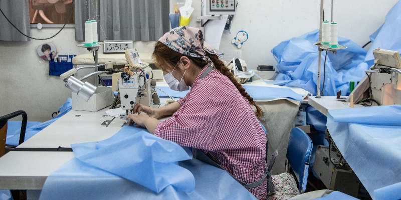 Una lavoratrice cuce un camice nella fabbrica Riviera a Sakai, in Giappone, il 14 maggio 2020 ( Carl Court/Getty Images)
