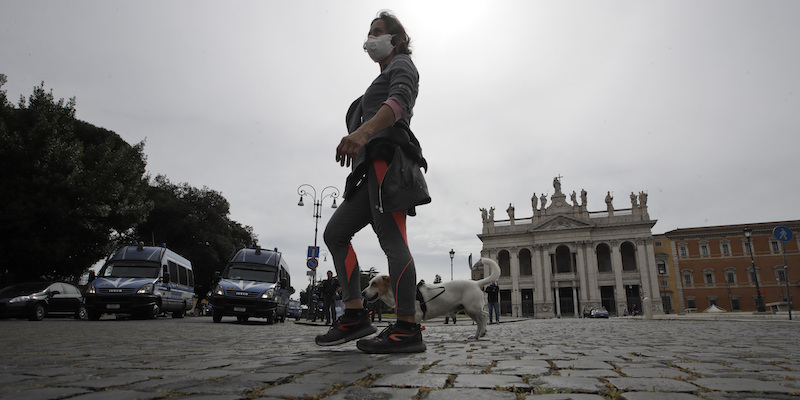 Una donna passeggia davanti alla basilica di San Giovanni in Laterano, a Roma, il primo maggio 2020 (La Presse/AP Photo/Alessandra Tarantino)