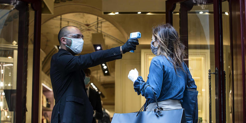 L'uso di un termoscanner fuori da un negozio di Roma, il 18 maggio 2020 (ANSA/ANGELO CARCONI)