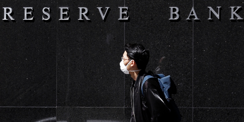 Un uomo con la mascherina passa davanti alla Reserve Bank of Australia a Sydney, giovedì 19 marzo 2020 (AP Photo/Rick Rycroft)