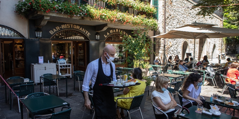 Un cameriere con mascherina protettiva serve alcuni clienti al Bar Marianna di Bergamo, il 18 giugno 2020 (Emanuele Cremaschi/Getty Images)