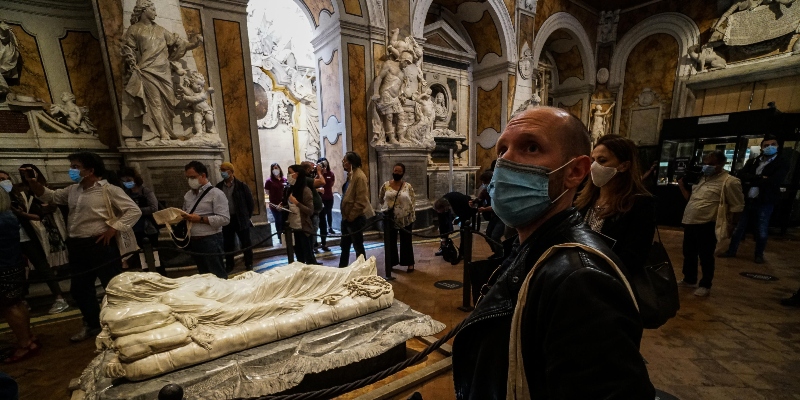 Turisti con la mascherina alla Cappella Sansevero davanti alla scultura "Cristo velato" di Giuseppe Sanmartino, a Napoli, l'11 giugno 2020 (ANSA/Cesare Abbate)