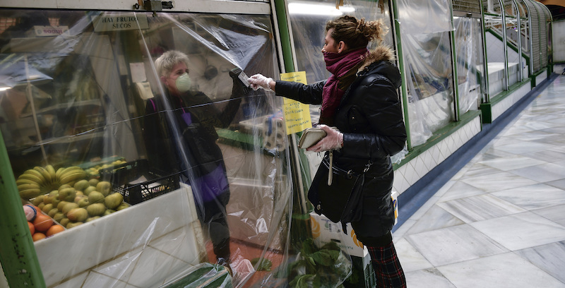 Un pagamento protetto da un telo di nylon nel mercato di Pamplona, Spagna. (AP Photo/Alvaro Barrientos)