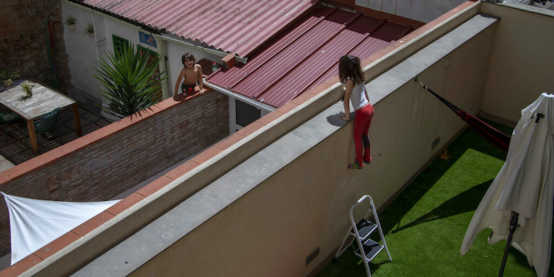 Gala di 7 anni e Oliver di 6, compagni di classe, si parlano da un cortile a un altro a Barcellona, durante il periodo di "lockdown", il 29 aprile 2020 (La Presse/AP Photo/Emilio Morenatti)