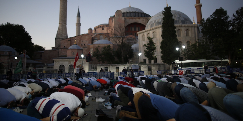 Musulmani pregano fuori dalla basilica di Santa Sofia, a Istanbul, dopo che il Consiglio di Stato turco ha stabilito che la decisione con cui fu trasformata da moschea in museo nel 1934 fu illegittima, il 10 luglio 2020 (La Presse/AP Photo/Emrah Gurel)