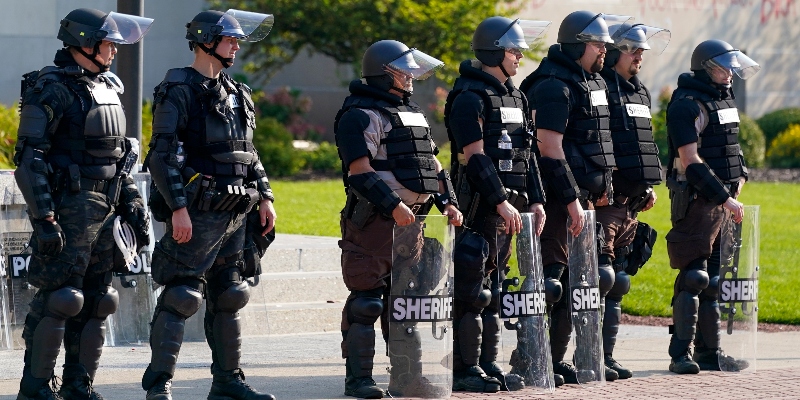 Agenti di polizia in tenuta antisommossa davanti al tribunale della contea di Kenosha, in Wisconsin, negli Stati Uniti, lunedì 24 agosto (AP/Morry Gash)