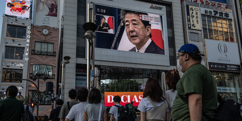 Passanti guardano la conferenza stampa con cui Shinzo Abe ha annunciato le sue dimissioni da primo ministro su uno schermo a Tokyo, il 28 agosto 2020 (Carl Court/Getty Images)