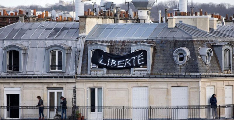 Uno striscione sul tetto di una casa di Parigi l'11 gennaio 2015, quando migliaia di persone si erano ritrovate nella Place de la République per manifestare dopo gli attentati. (AP Photo/Peter Dejong, File / LaPresse)