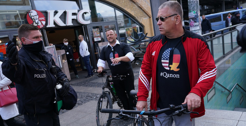 Due manifestanti con una maglietta di QAnon a Berlino, durante una protesta contro le misure restrittive per il coronavirus. (Sean Gallup/Getty Images)