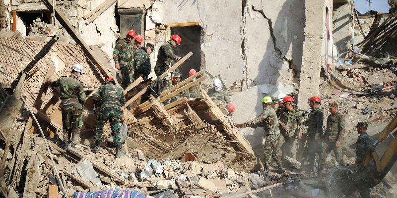 Soccorritori al lavoro fra le macerie di una casa bombardata dall'artiglieria armena, durante i combattimenti per la regione separatista del Nagorno-Karabakh, a Ganja, in Azerbaijan, domenica 11 ottobre 2020 (AP Photo / Aziz Karimov)
