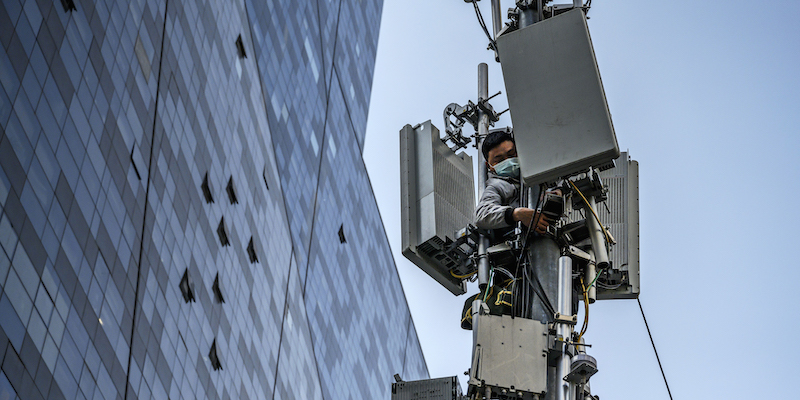 Un operaio monta un'antenna 5G a Pechino (Kevin Frayer/Getty Images)