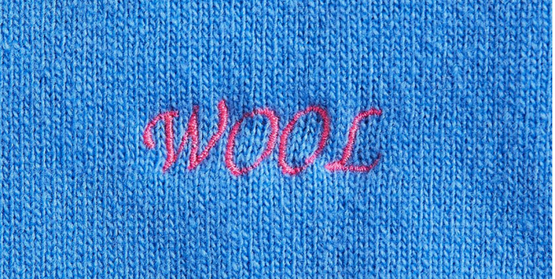 Una scritta ricamata su un maglione di Benetton (Benetton)