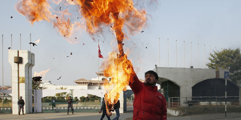 Un uomo protesta contro lo scioglimento della Camera bruciando l'immagine del primo ministro K. P. Sharma Oli davanti al Parlamento a Katmandu, in Nepal (Niranjan Shrestha/AP Photo, LaPresse)
