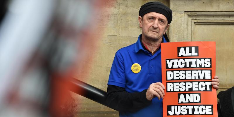 Una persona con in mano un cartello che dice «tutte le vittime meritano rispetto e giustizia», durante una protesta del 2019 dei sopravvissuti agli abusi, fuori dal Parlamento dello Stato di Victoria, a Melbourne (James Ross/Epa, Ansa)