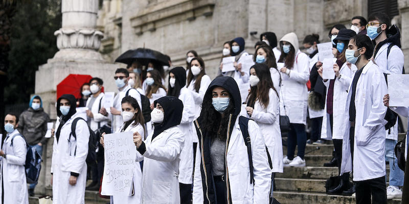 I medici specializzandi, con camici bianchi e cartelli, protestano davanti al ministero dell'Istruzione, a Roma (ANSA / RICCARDO ANTIMIANI)