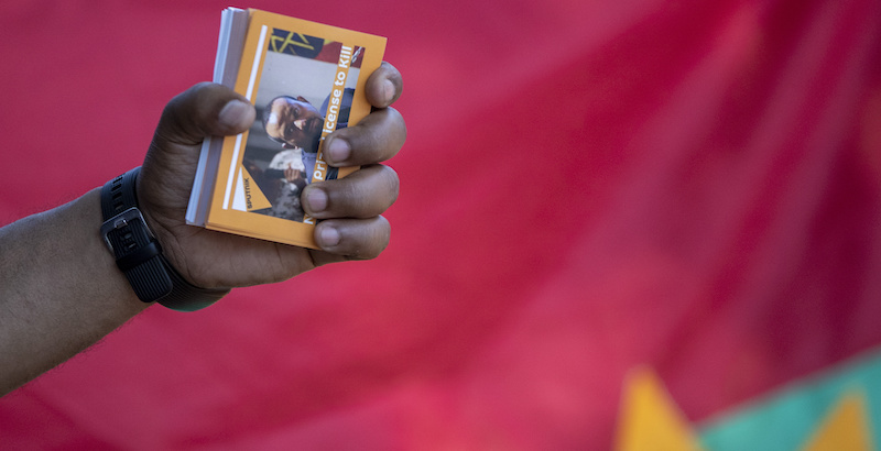 Un tigrino tiene in mano un libretto con scritto "La licenza di uccidere di un premio Nobel", con sopra l'immagine del primo ministro etiope (AP Photo/Themba Hadebe)