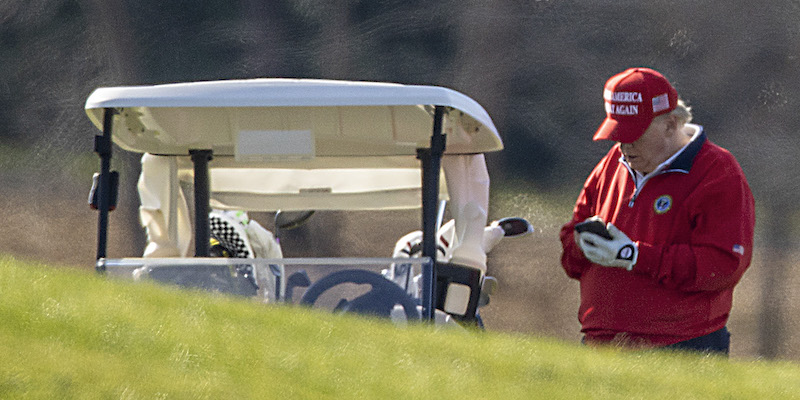 Donald Trump al telefono durante una partita di golf (Tasos Katopodis/Getty Images)