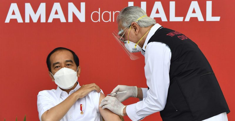 Il presidente dell’Indonesia, Joko Widodo, viene vaccinato con il vaccino contro il coronavirus prodotto dall’azienda cinese Sinovac. La scritta dietro di lui dice "sicuro e halal". Giacarta, Indonesia, 13 gennaio 2021. (Agus Suparto/ Palazzo presidenziale indonesiano, via AP)