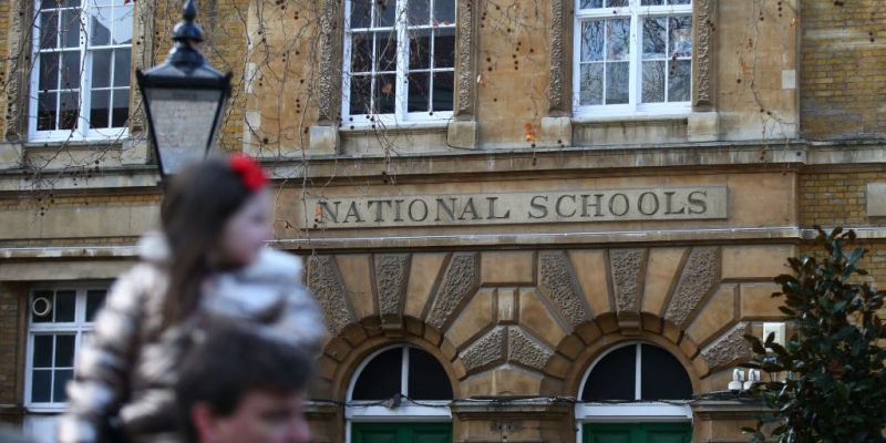 Un uomo con la figlia davanti alla scuola elementare di St. Marylebone a Londra, il 3 gennaio 2021. Tutte le scuole elementari di Londra saranno chiuse fino al 18 gennaio. (Hollie Adams/ Getty Images)