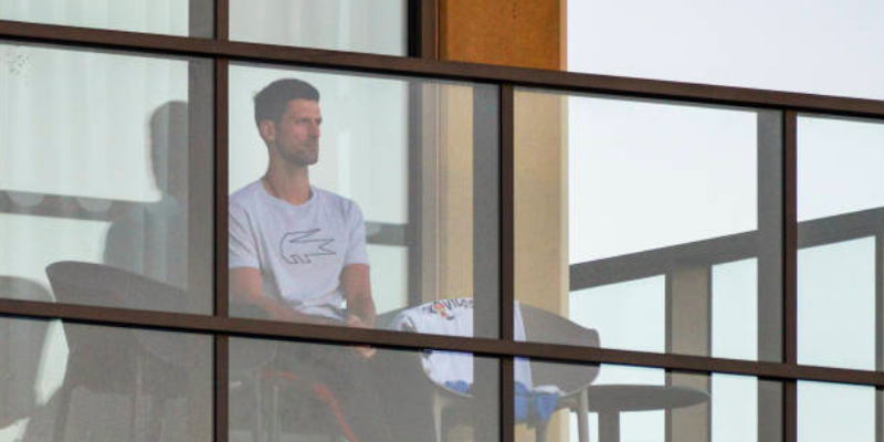 Novak Djokovic sul balcone della sua stanza di hotel ad Adelaide, in Australia (BRENTON EDWARDS/AFP via Getty Images)
