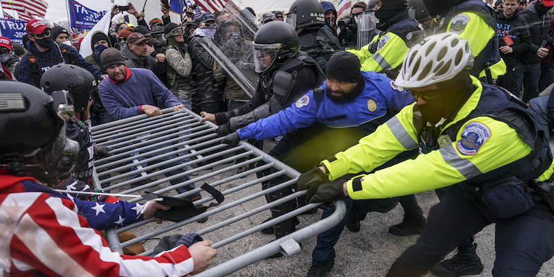 Sostenitori di Trump mercoledì fuori dal Congresso, mentre sfondano una barriera della polizia(AP Photo/John Minchillo)