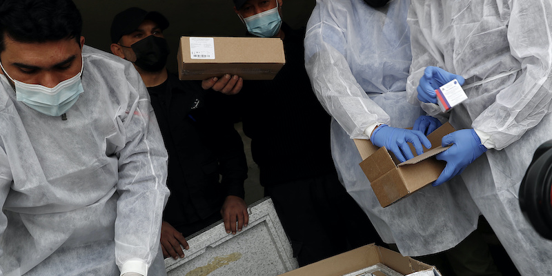 Medici e agenti di polizia controllano una spedizione del vaccino russo Sputnik V a Rafah, nella striscia di Gaza (AP Photo/Adel Hana, LaPresse)