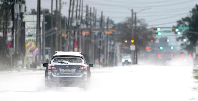 Un'auto percorre una strada innevata a Spring, vicino a Houston, nel sud del Texas. (AP Photo/ David J. Phillip)