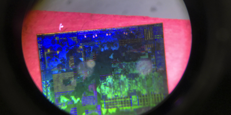 Un microchip visto al microscopio a una fiera di tecnologia a Pechino, nel 2018 (AP Photo/Ng Han Guan)