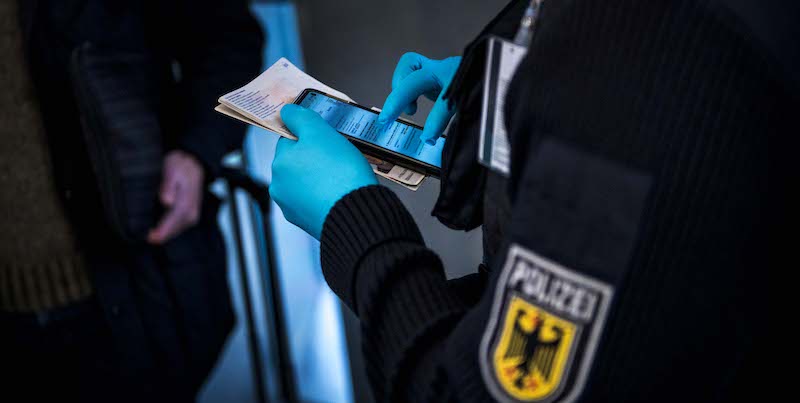 Un poliziotto controlla il certificato di un test negativo al coronavirus di un passeggero arrivato in Germania dalla Spagna, all'aeroporto di Francoforte (Thomas Lohnes/Getty Images)