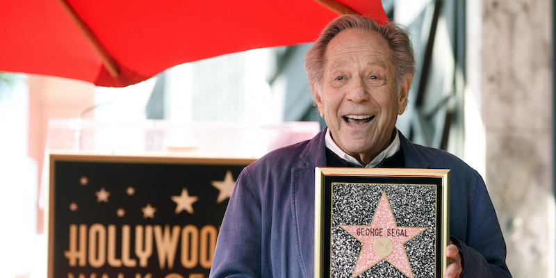 George Segal fotografato con la replica della stella a lui dedicata nella "Walk of fame" di Hollywood, a Los Angeles, nel 2017 (Chris Pizzello/Invision/AP)