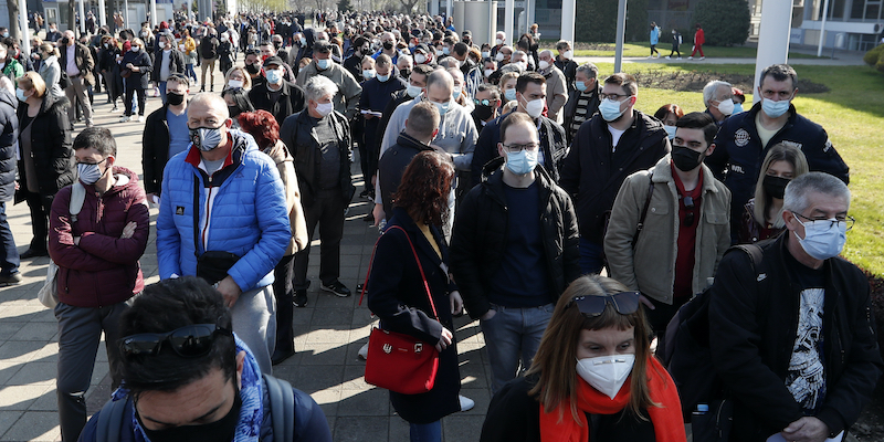 A Belgrado, in Serbia, persone provenienti da altri paesi aspettano in coda per ricevere una dose del vaccino di AstraZeneca, il 27 marzo 2021 (AP Photo/Darko Vojinovic)