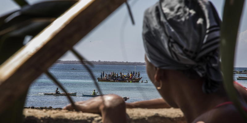 Una donna osserva le persone, scappate dalle loro case, su una barca a largo della spiaggia di Pemba, nel nord del Mozambico (epa/Ricardo Franco/Ansa)