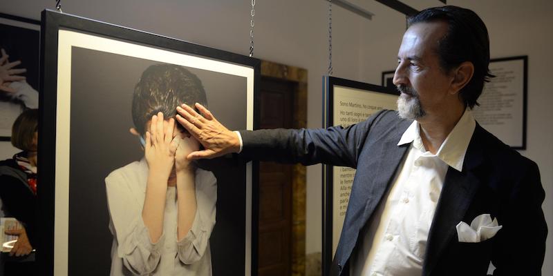 Giovanni Gastel davanti a una delle sue fotografie, nel 2013 (ANSA / MAURIZIO BRAMBATTI)