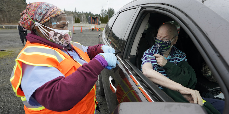Un uomo riceve il vaccino contro il coronavirus nella sua auto, a Shelton, nello stato di Washington, Stati Uniti (AP Photo/Ted S. Warren)