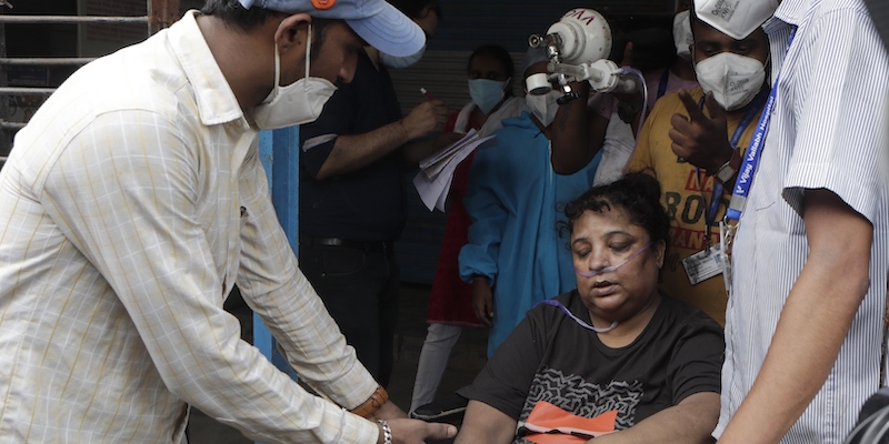 Operatori sanitari trasportano una paziente fuori dall'ospedale dove è scoppiato l'incendio a Virar, vicino a Mumbai, in India, il 23 aprile (AP Photo/Rajanish Kakade)