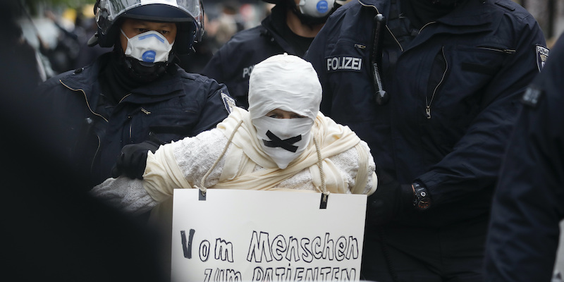 Una persona arrestata da agenti di polizia durante una manifestazione illegale contro le restrizioni per il coronavirus a Berlino, in Germania (AP Photo/Markus Schreiber, file)