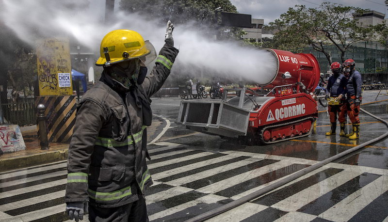 Vigili del fuoco spruzzano disinfettante nelle strade di Manila, Filippine (Ezra Acayan/Getty Images)