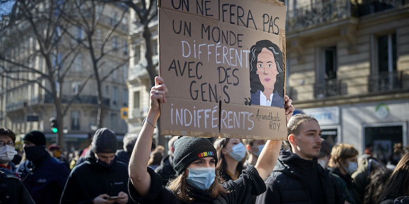 Una protesta a Parigi contro la legge sulla sicurezza, il 20 marzo 2021. Una ragazza tiene in mano un cartello con scritto: «Non faremo un mondo differente, con gente indifferente» (Kiran Ridley/Getty Images)