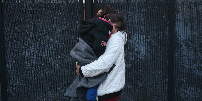 Un uomo siriano con in braccio la figlia addormentata fermati dalla polizia a Padborg, in Danimarca, al confine con la Germania, dove transitano spesso migranti e rifugiati, in molti casi provenienti dalla Siria (Sean Gallup/Getty Images)