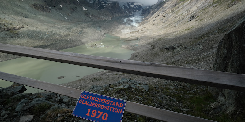 Un cartello indica dove arrivava il ghiacciaio austriaco Pasterze nel 1970, mentre sullo sfondo si vede il ghiacciaio com'era nell'agosto del 2019 (Sean Gallup/Getty Images)