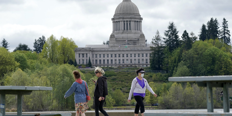 Persone con e senza mascherina camminano vicino al Campidoglio, a Washington, negli Stati Uniti (AP Photo/Ted S. Warren)