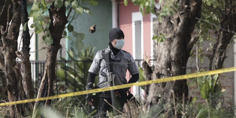 Un agente di polizia vicino alla casa dove sono state trovate decine di corpi interrati, nella città di Chalchuapa, a El Salvador (AP Photo/Salvador Melendez)