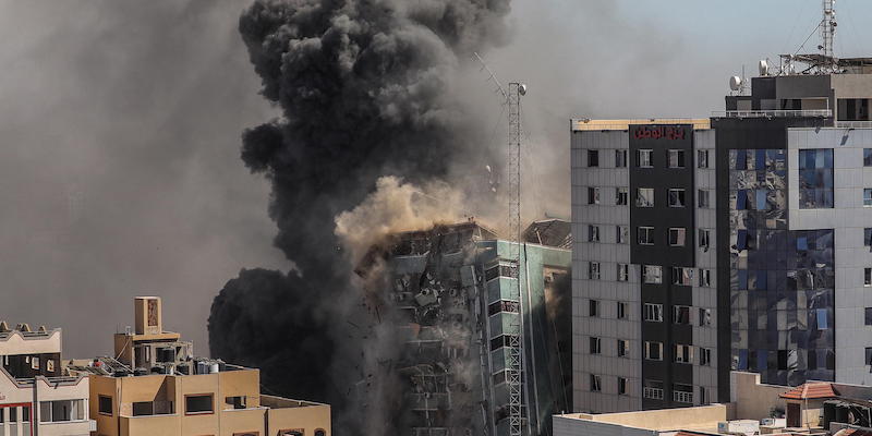 Il crollo dell'edificio di Al-Jalaa, nel centro di Gaza, bombardato dall'esercito israeliano: l'edificio ospitava le sedi di diversi media internazionali, tra cui Associated Press e Al Jazeera (ANSA/EPA/MOHAMMED SABER)