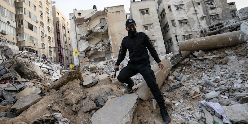 Un poliziotto cammina tra le rovine a Gaza (AP Photo/John Minchillo)