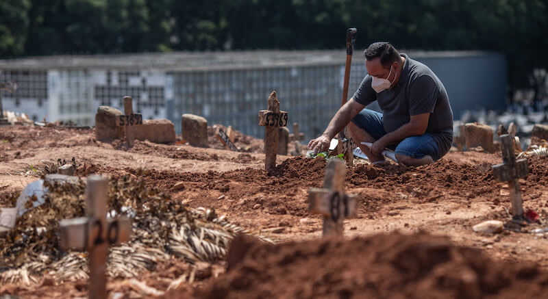 La visita a un parente deceduto per COVID-19 in un cimitero di Rio de Janeiro, Brasile, alla fine del 2020 (Andre Coelho/Getty Images)