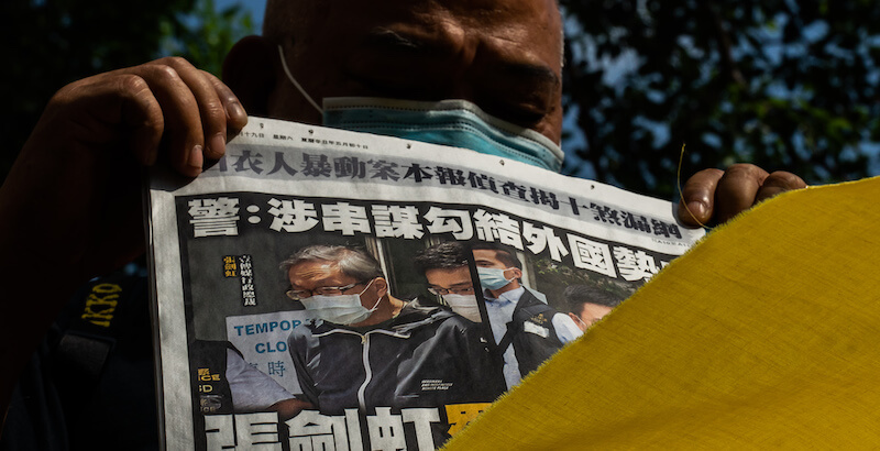 Un lettore dell'Apple Daily mostra una copia del giornale, il 19 giugno a Hong Kong (Anthony Kwan/Getty Images)