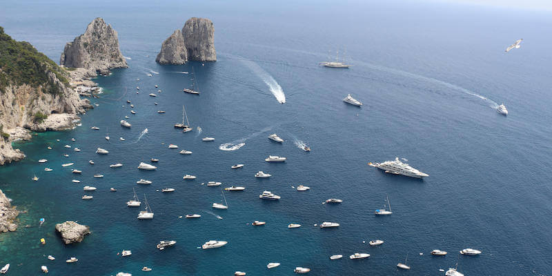 Barche davanti ai Faraglioni a Capri (ANSA/ GIUSEPPE CATUOGNO)