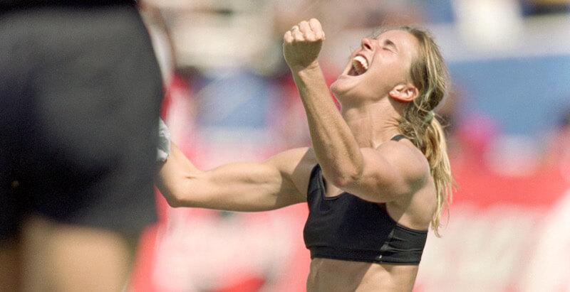 Brandi Chastain esulta togliendosi la maglietta e si lascia andare in un urlo liberatorio, dopo aver segnato il rigore decisivo nella finale del Mondiale del 1999 negli Stati Uniti (Jed Jacobsohn/Getty Images)