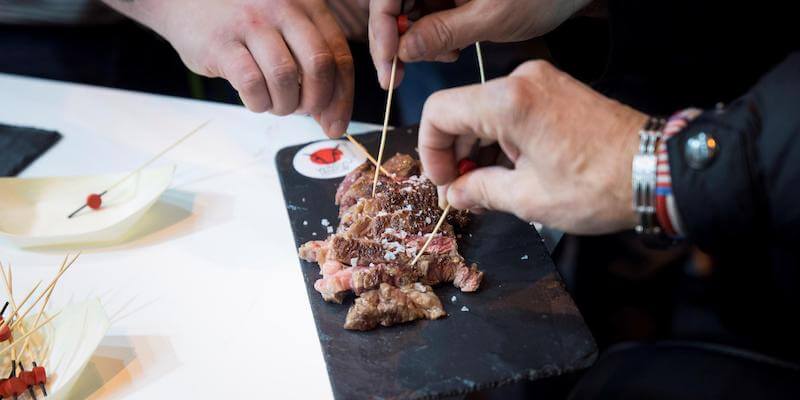 Assaggi di carne di manzo a una fiera di Madrid (EPA/Luca Piergiovanni)