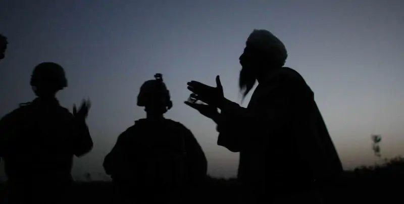 Da sinistra, un interprete, un soldato statunitense e un uomo afghano a colloquio nella città di Mian Poshteh, in Afghanistan (Joe Raedle/Getty Images)